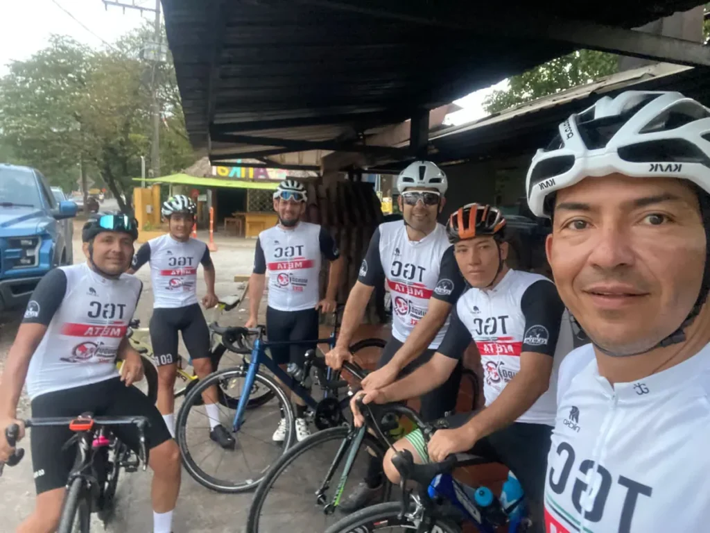 Grupo de ciclistas con jerseys personalizados en una parada de ruta - NICKO Deportes